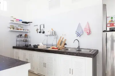 a kitchen with white cabinets and a sink at Cozy 2br villa at the beach in Canggu