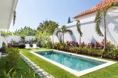 a swimming pool in the yard of a house at Cozy 2br villa at the beach in Canggu