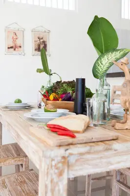 a table with a cutting board with vegetables on it at Cozy 2br villa at the beach in Canggu