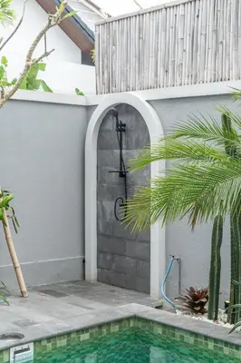 a shower in a wall next to a swimming pool at Villa Delila in Canguu in Canggu