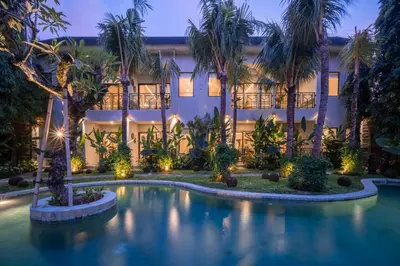 an exterior view of a resort with a swimming pool at night at Anam Mani New Room Central Seminyak in Seminyak