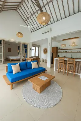 a living room with a blue couch and a table at Blush Elegance 2 BR Villa in Umalas in Canggu