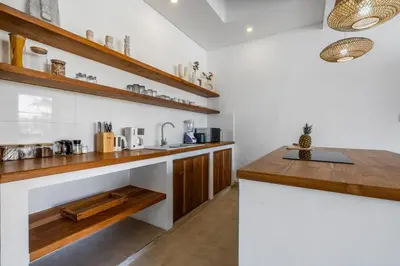 a kitchen with white walls and wooden counter tops at Blush Elegance 2 BR Villa in Umalas in Canggu
