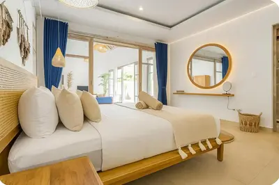 a bedroom with a large bed and a mirror at Blush Elegance 2 BR Villa in Umalas in Canggu