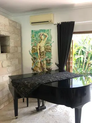 a black piano in a room with a painting on the wall at Beachside Luxury Private Villa in Sanur in Sanur