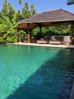 a swimming pool with a gazebo and blue water at Beachside Luxury Private Villa in Sanur in Sanur