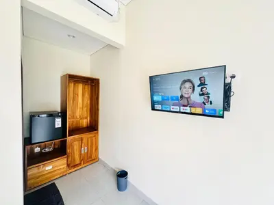 a flat screen tv hanging on a wall at Umah Anami in Denpasar