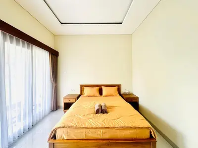 a bedroom with a dog laying on a bed at Umah Anami in Denpasar