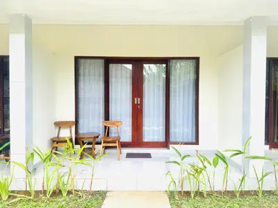 two chairs on the front porch of a house at Umah Anami in Denpasar