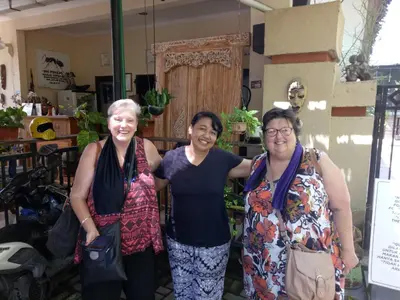 three women posing for a picture in a store at Pujihouse One in Legian