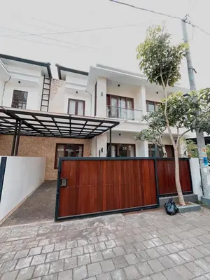 a house with a wooden gate in front of it at Villa Morich in Jimbaran