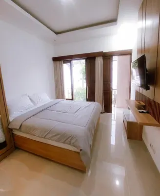 a bedroom with a large bed and a television at Villa Morich in Jimbaran