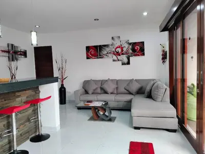 a living room with a gray couch and a fireplace at Villa Toya in Legian