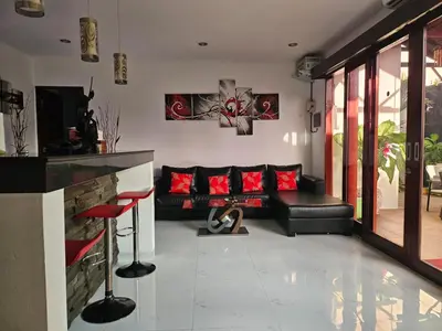 a living room with a black couch and red pillows at Villa Toya in Legian