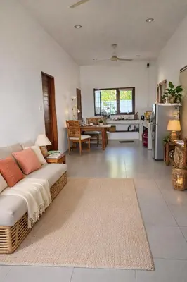 a living room with a couch and a kitchen at Nuansa Timur Residence in Jimbaran