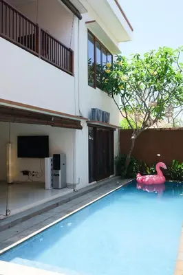 a pool in front of a house with a pink flamingo in the water at 5beds, 10 ppl, 10mins to beach, Private Pool in Sanur