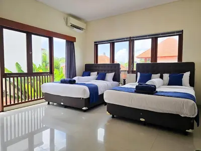 two beds sitting in a room with windows at 5beds, 10 ppl, 10mins to beach, Private Pool in Sanur