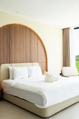 a bedroom with a large bed with a wooden headboard at Casa Alden - 3BR Infinity Pool with Ricefield View in Kerobokan