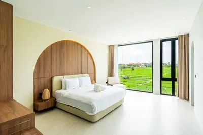 a bedroom with a large bed and a large window at Casa Alden - 3BR Infinity Pool with Ricefield View in Kerobokan