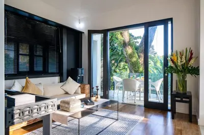 a living room with a couch and a glass table at Walk into Serenity, Martini 3 - 1BR Treetop Villa in Kerobokan