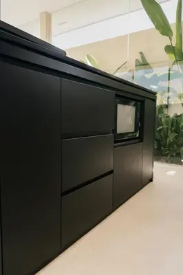 a black dresser in a room with plants at Villa Kina - Tropical 2BR Villa with Pool and Billiard in Seminyak