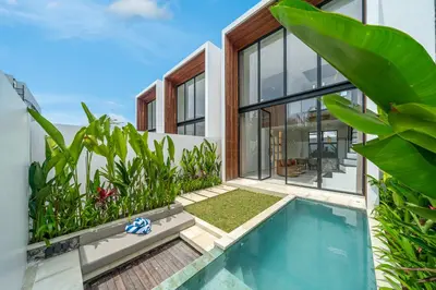 an exterior view of a house with a swimming pool at Hidden Elements in Canggu