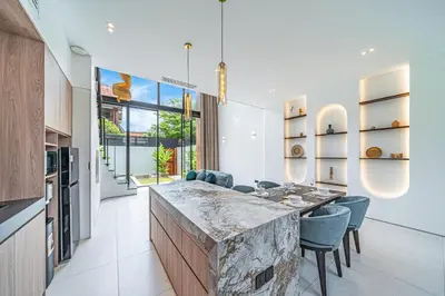 a kitchen with a stone counter and blue chairs at Hidden Elements in Canggu