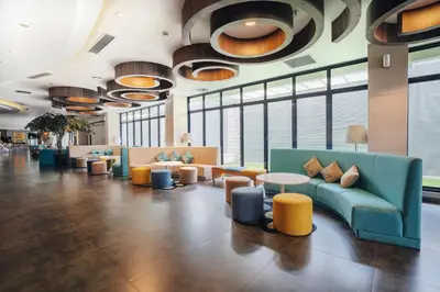 a lobby with couches and tables and windows at Kamaniiya Petitenget Seminyak in Seminyak