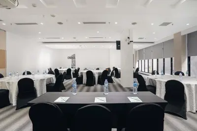 a conference room with tables and chairs with water bottles on them at Kamaniiya Petitenget Seminyak in Seminyak