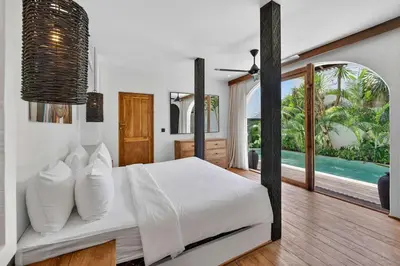 a bedroom with a bed and a view of the ocean at Black Diamond - Luxury 3BR Villa in Umalas in Kerobokan