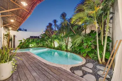 a swimming pool on a deck next to a house at Black Diamond - Luxury 3BR Villa in Umalas in Kerobokan