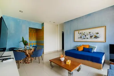 a living room with a bed and a dining room at Amelia D Art Deco Suites in Seminyak