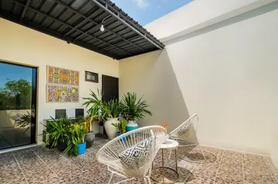 a patio with wicker chairs and plants at Amelia D Art Deco Suites in Seminyak