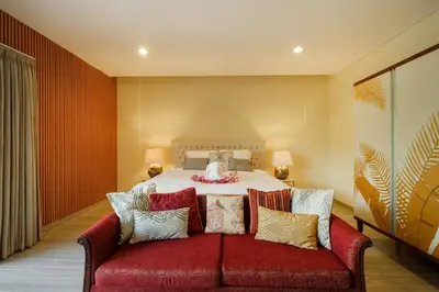 a bedroom with a bed with a red couch at Amelia D Art Deco Suites in Seminyak