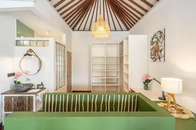 a living room with a green couch and a ceiling at Villa Arisanti in Kerobokan