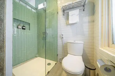 a bathroom with a toilet and a glass shower at Villa Arisanti in Kerobokan