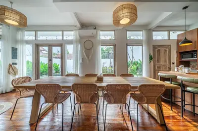 a large dining room with a large wooden table and chairs at Villa Arisanti in Kerobokan