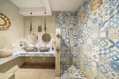 a bathroom with two sinks and blue and white tiles at Villa Arisanti in Kerobokan