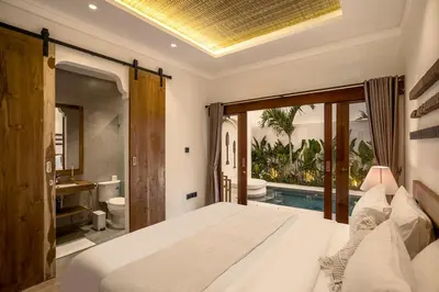 a bedroom with a bed and a swimming pool at Priviere Seminyak - 2BR Villa with Pool Near Beach in Seminyak