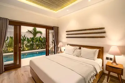 a bedroom with a bed and a swimming pool at Priviere Seminyak - 2BR Villa with Pool Near Beach in Seminyak