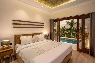 a bedroom with a bed and a swimming pool at Priviere Seminyak - 2BR Villa with Pool Near Beach in Seminyak