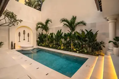 a swimming pool in a building with plants at Priviere Seminyak - 2BR Villa with Pool Near Beach in Seminyak
