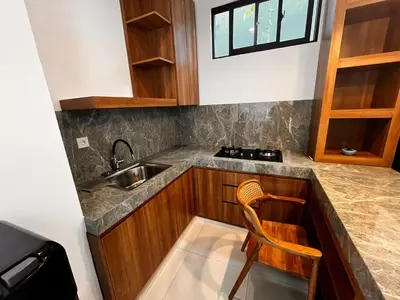 a kitchen with a sink and a chair in it at BEN & B Villa 2 in Kerobokan