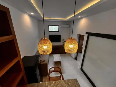 a room with two hanging lights and a table and chairs at BEN & B Villa 2 in Kerobokan