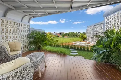 a balcony with chairs and a view of a garden at Luxury Couple 2 BR Villa Umalas, Rooftop, Pool & View in Kerobokan