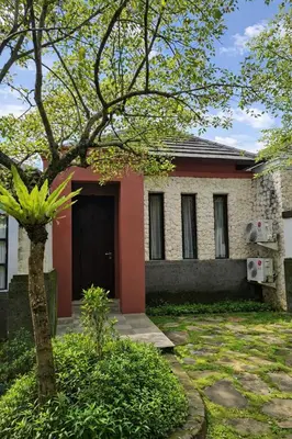 a house with a tree in front of it at Royal Tulip Springhill Resort Villa Kunyit 12 in Jimbaran