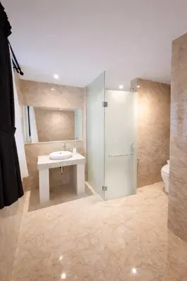 a bathroom with a sink and a shower and a toilet at Royal Tulip Springhill Resort Villa Kunyit 12 in Jimbaran