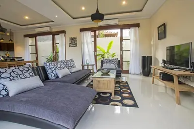 a living room with a couch and a tv at Villa Aurikari in Legian