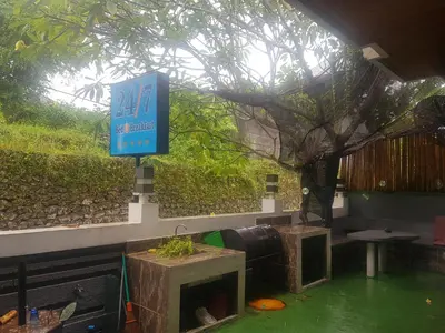 a sign for a restaurant with a tree in the middle at 24/7 Bed & Breakfast in Jimbaran