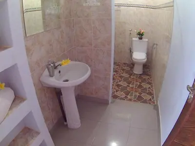 a bathroom with a sink and a toilet at 24/7 Bed & Breakfast in Jimbaran